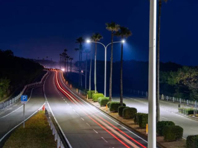 Illuminated street lighting along a coastal road at night in Oman